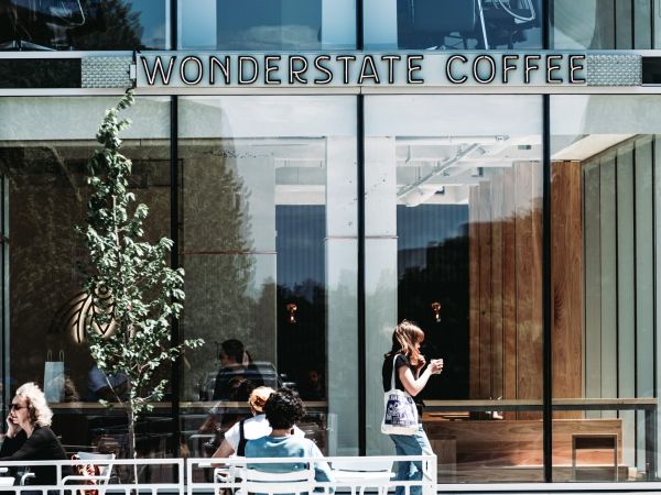 Outside signage for Wonderstate Coffee with customers sitting in the sun